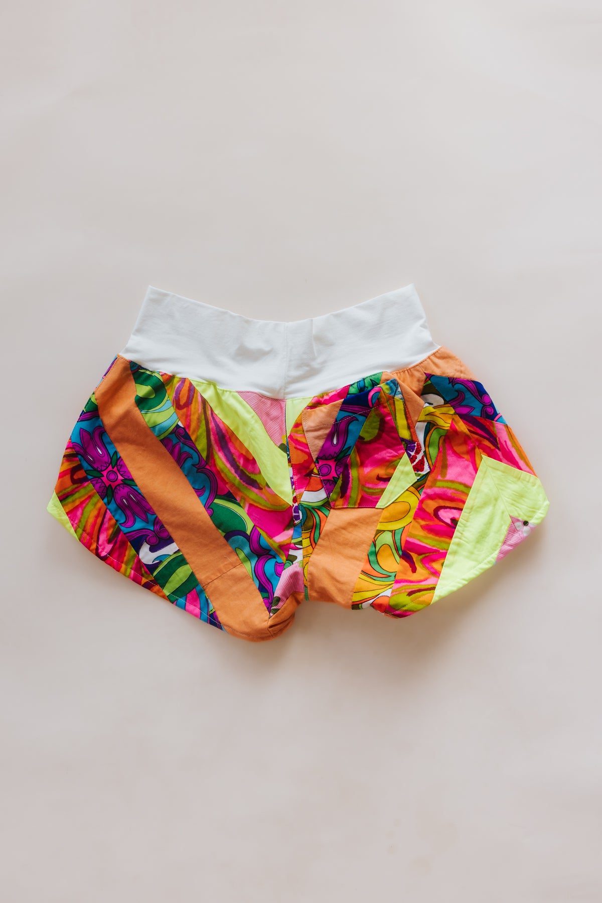Wings Hawaii Patchwork Pau Hana Shorts in Tropic Rush. Handmade, one of a kind, upcycled vintage quilt fabric. Stretchy cotton waistband and back pocket. Made with aloha in Maui. Sustainable, small batch, slow fashion. 
