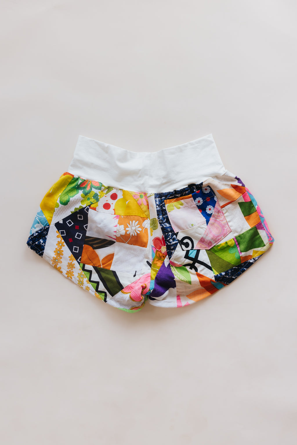 Wings Hawaii Patchwork Pau Hana Shorts in Daisy Lane. Handmade, one of a kind, upcycled vintage quilt fabric. Cozy cotton waistband and back pocket. Made with aloha in Maui. Sustainable, small batch, slow fashion. 