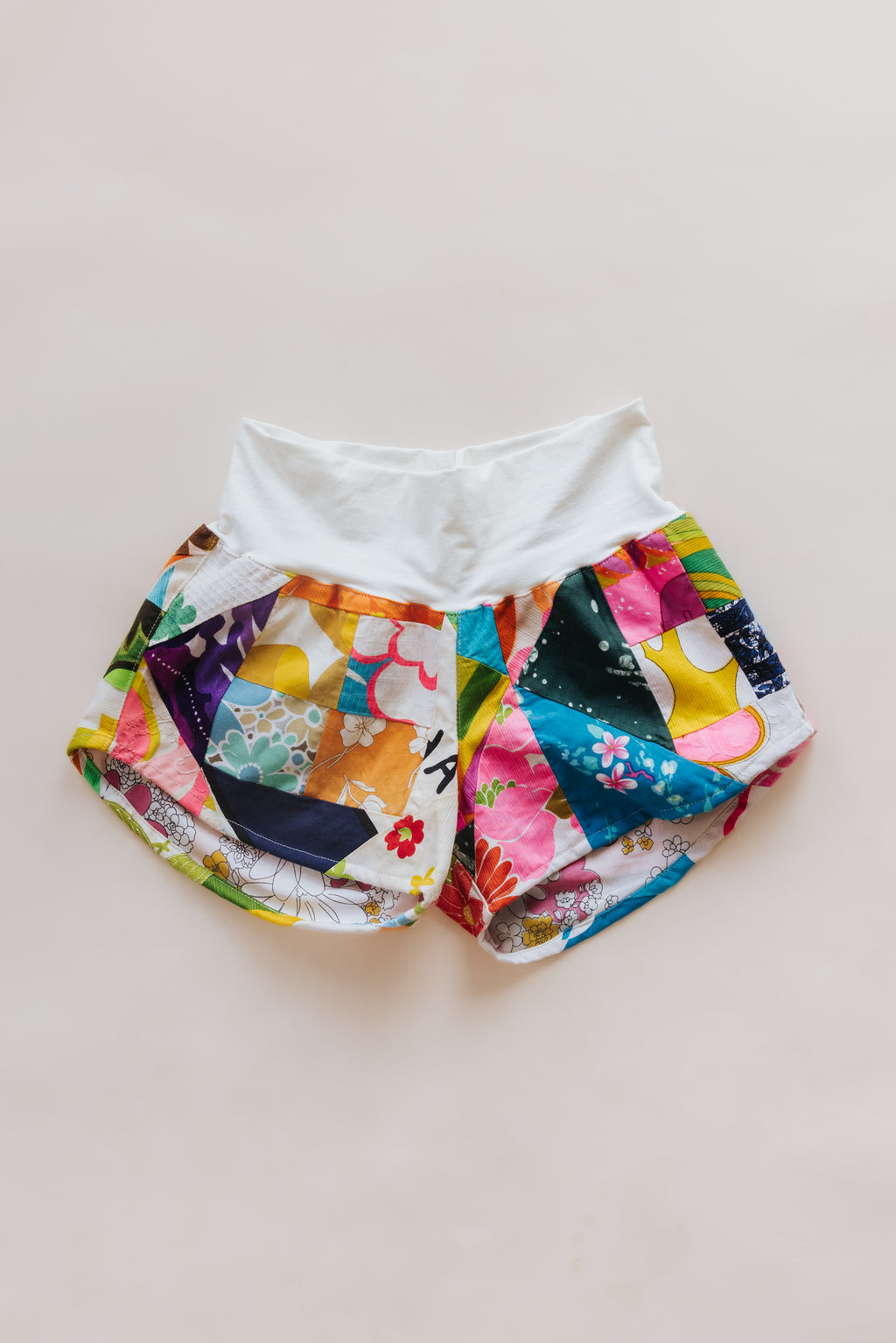 Wings Hawaii Patchwork Pau Hana Shorts in Daisy Lane. Handmade, one of a kind, upcycled vintage quilt fabric. Cozy cotton waistband and back pocket. Made with aloha in Maui. Sustainable, small batch, slow fashion. 