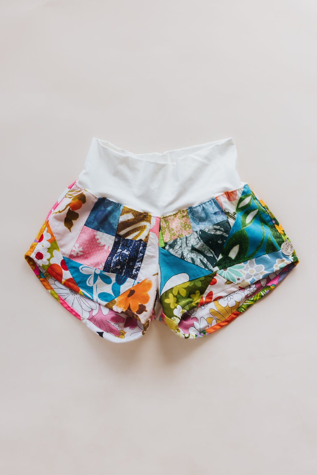 Wings Hawaii Patchwork Pau Hana Shorts in Daisy Lane. Handmade, one of a kind, upcycled vintage quilt fabric. Cozy cotton waistband and back pocket. Made with aloha in Maui. Sustainable, small batch, slow fashion. 