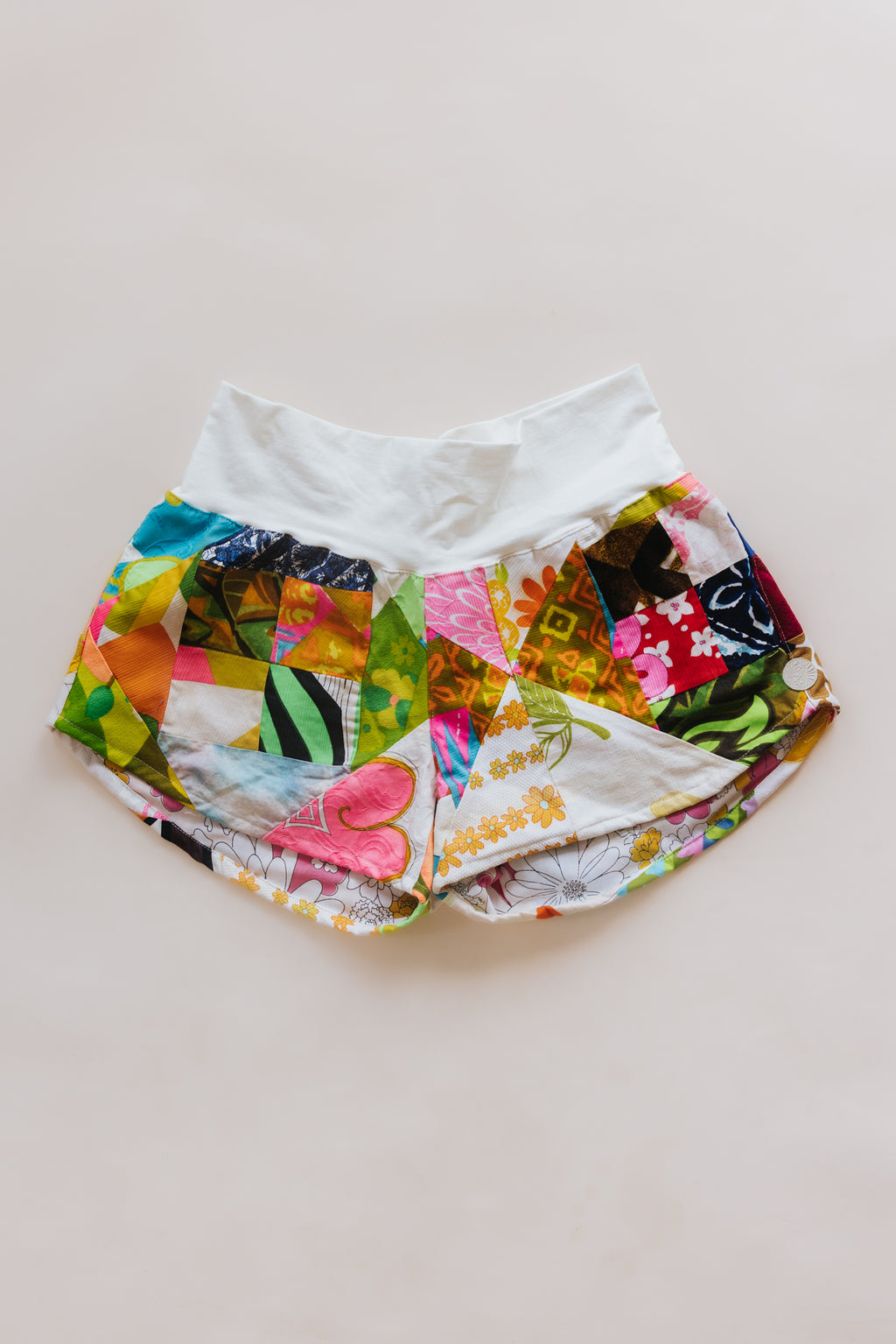 Wings Hawaii Patchwork Pau Hana Shorts in Daisy Lane. Handmade, one of a kind, upcycled vintage quilt fabric. Cozy cotton waistband and back pocket. Made with aloha in Maui. Sustainable, small batch, slow fashion. 