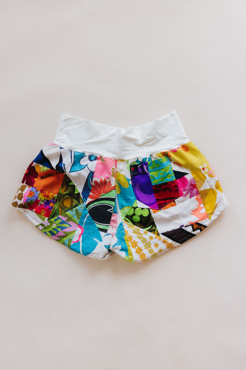 Wings Hawaii Patchwork Pau Hana Shorts in Daisy Lane. Handmade, one of a kind, upcycled vintage quilt fabric. Cozy cotton waistband and back pocket. Made with aloha in Maui. Sustainable, small batch, slow fashion. 