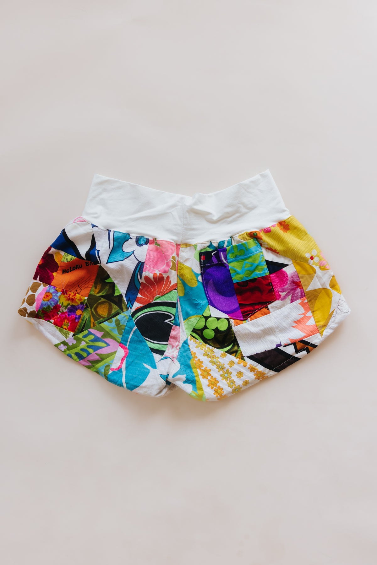 Wings Hawaii Patchwork Pau Hana Shorts in Daisy Lane. Handmade, one of a kind, upcycled vintage quilt fabric. Cozy cotton waistband and back pocket. Made with aloha in Maui. Sustainable, small batch, slow fashion. 