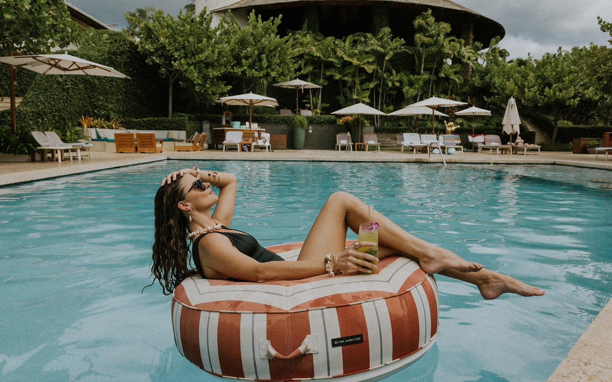 Model floating on a striped ring in the pool