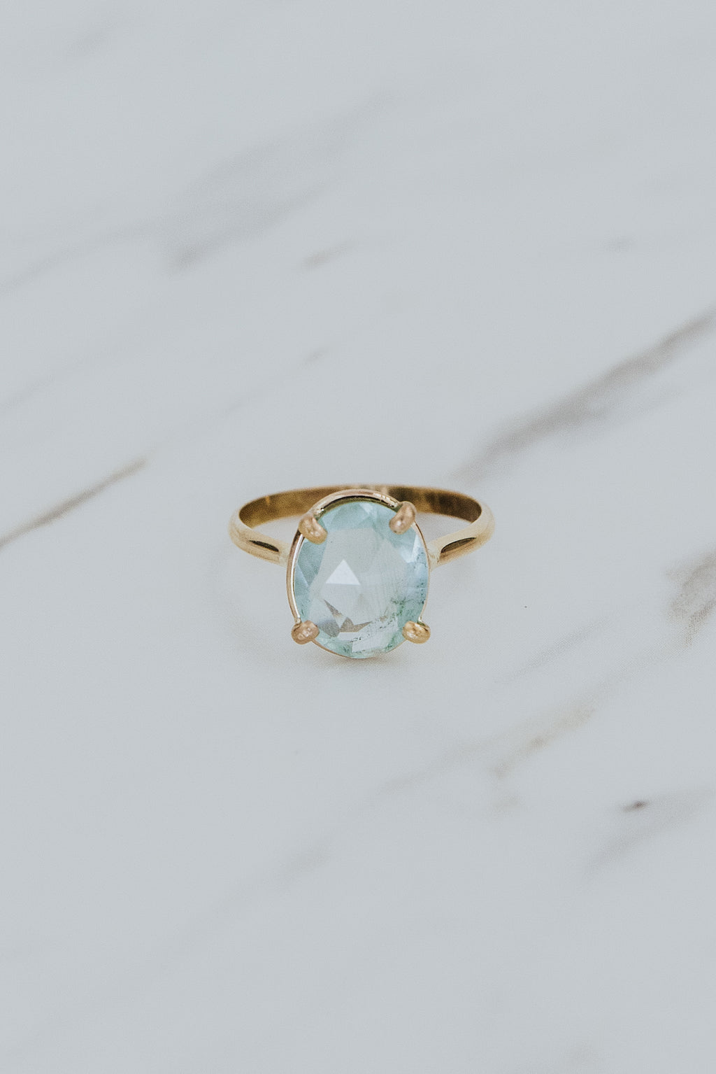 Wings Hawaii rose-cut, prong set Aquamarine Lyra ring in 14k gold-filled. Fine jewelry handcrafted in Maui. Light blue round gemstone in delicate gold ring. High quality jewelry made in Hawaii. 
