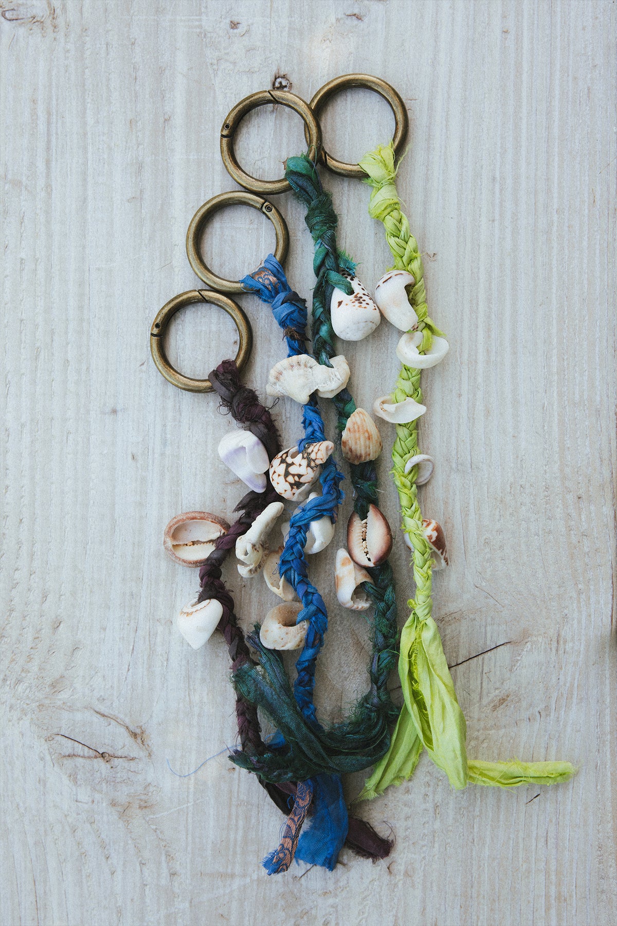 Wings Hawaii Shell Purse Charms Keychains with real Hawaiian beach shells and jewel tone braided silk ribbon on a brass ring. Handmade in Maui. Great gift or island souvenir. 