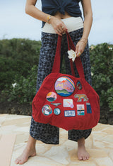 Wings Hawaii patched up cotton duffel bag in red. Original artwork on embroidered patches - mermaids, surfer girls, whales, tigers, rainbows and more. Handmade with aloha in Maui.  thumbnail