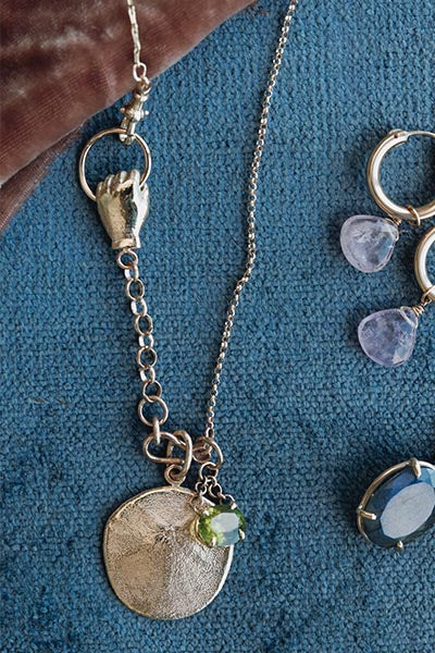 Wings Hawaii The Boss Charm Collector necklace in solid 14k yellow gold. Hand grasping loop, sand dollar charm. Fine jewelry handcrafted in Maui. The ultimate statement piece in custom charm collecting. 
