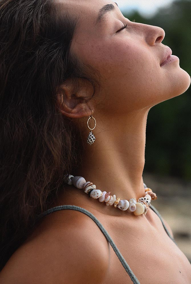 Model in profile wearing a shell necklace