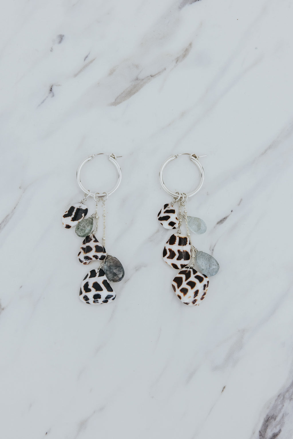 Wings Hawaii Shell Pile Hoop Earrings in sterling silver with Hebrew Cone Shells and aquamarine beads. Fine jewelry gifts handmade in Maui. 