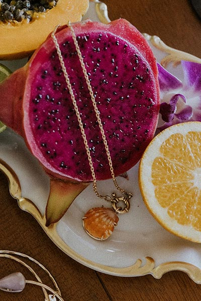 Necklace on a plate with dragon fruit and orange