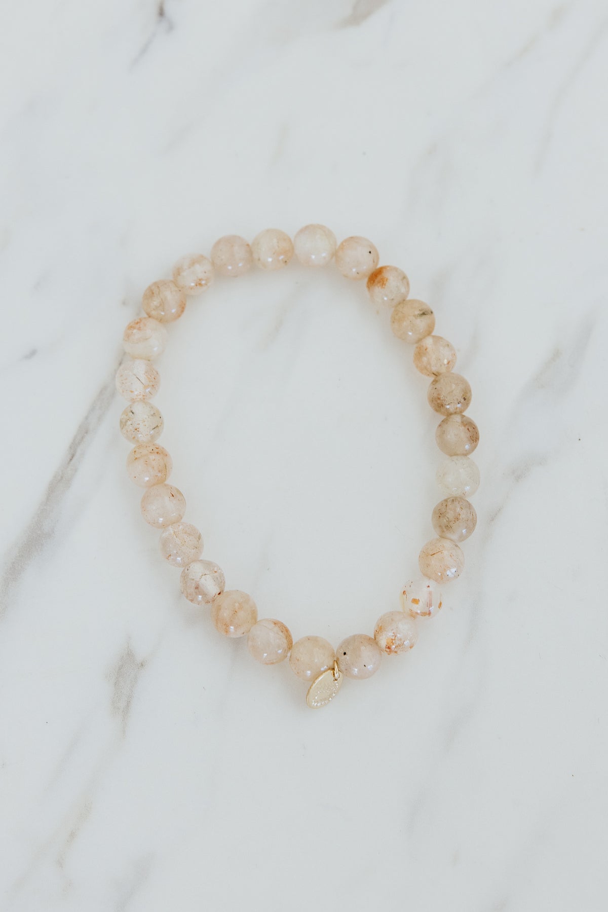 Wings Hawaii Sunstone stretchy beaded bracelet with 14k gold-filled tag. Crystal chakra healing. Boho-chic spiritual jewelry handmade in Maui.