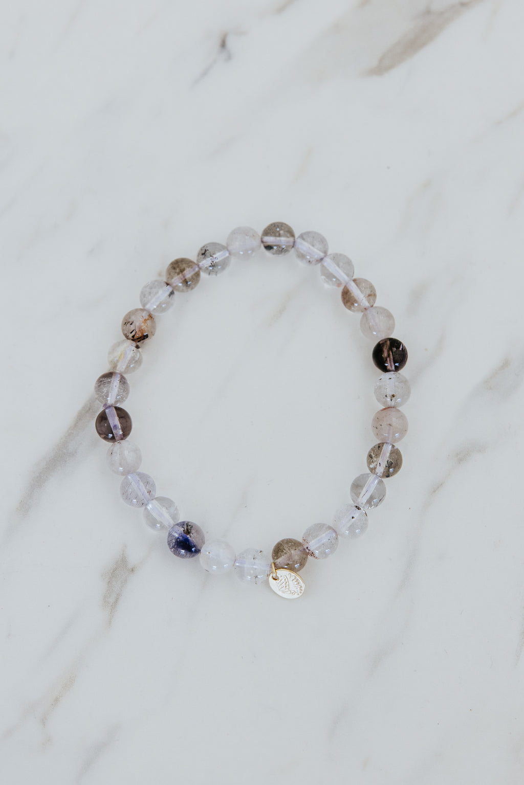 Wings Hawaii Light Super Seven stretchy beaded bracelet with 14k gold-filled tag. Crystal chakra healing. Boho-chic spiritual jewelry hand made in Maui.