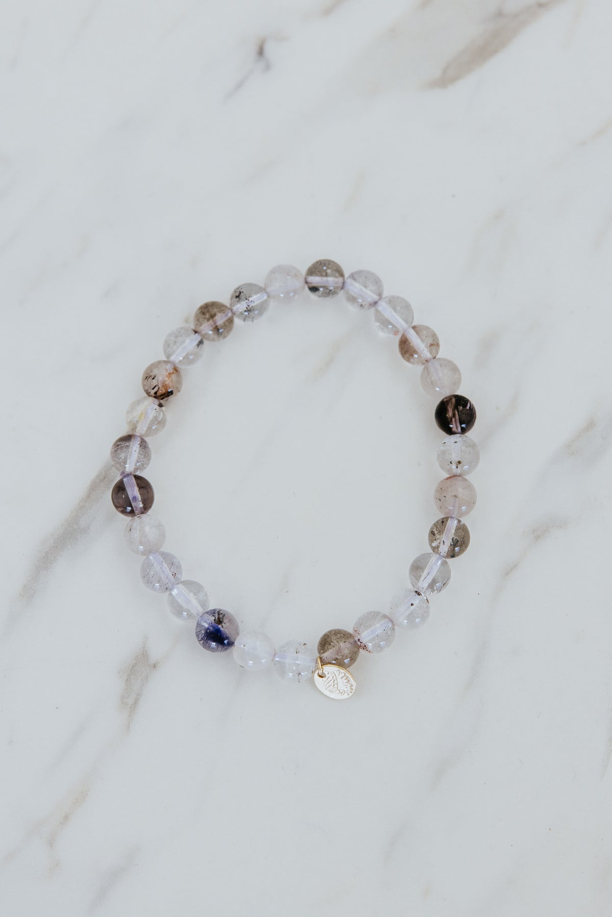 Wings Hawaii Light Super Seven stretchy beaded bracelet with 14k gold-filled tag. Crystal chakra healing. Boho-chic spiritual jewelry hand made in Maui.