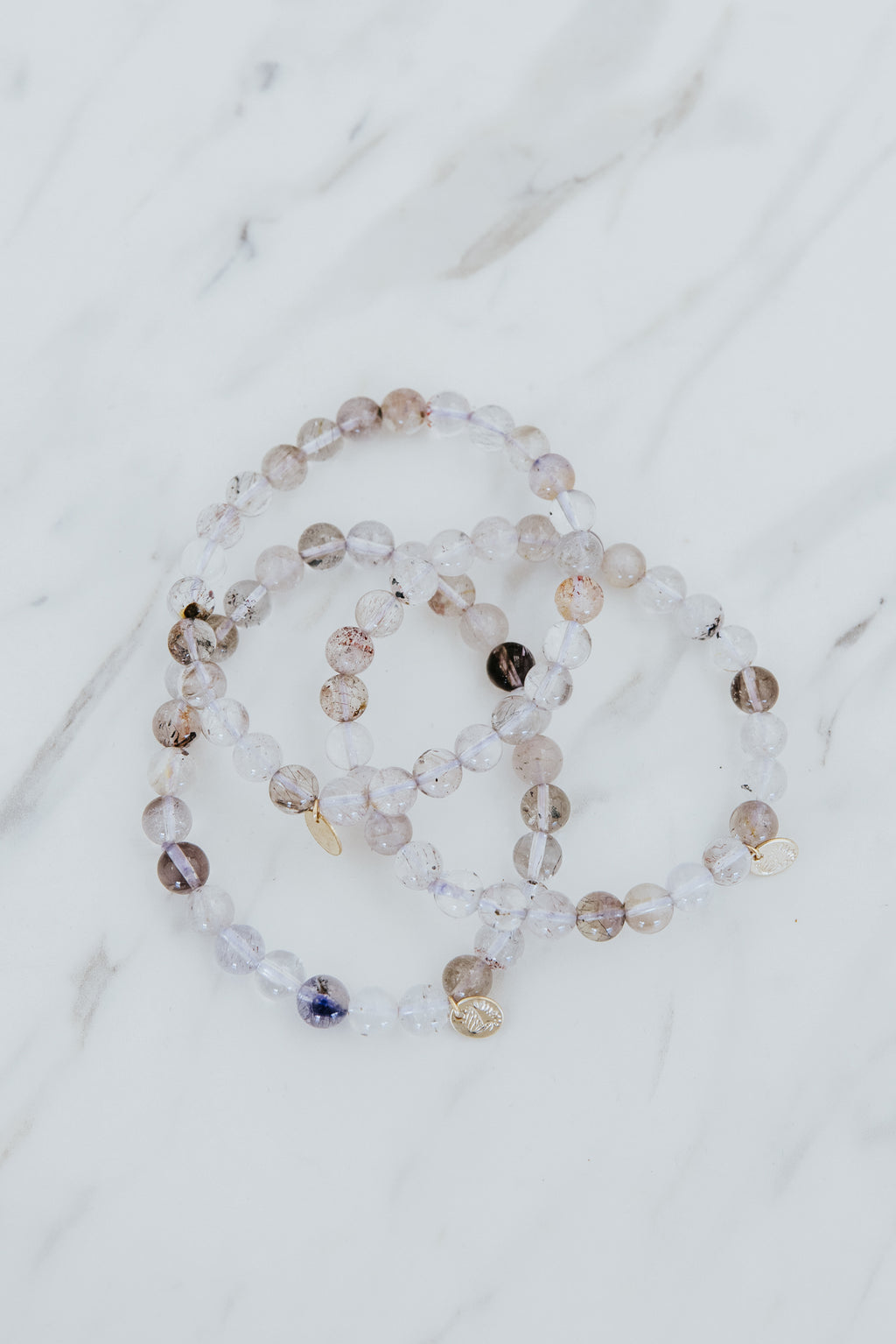 Wings Hawaii Light Super Seven stretchy beaded bracelet with 14k gold-filled tag. Crystal chakra healing. Boho-chic spiritual jewelry hand made in Maui.