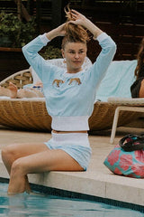 Model wearing Wings Hawaii blue french terry pau hana shorts and tiger raglan sweatshirt, with hibiscus adventure tote bag shown thumbnail