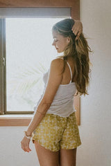 Model wearing Wings Hawaii retro pocket shorts in quilted ulu and plumeria print in marigold thumbnail