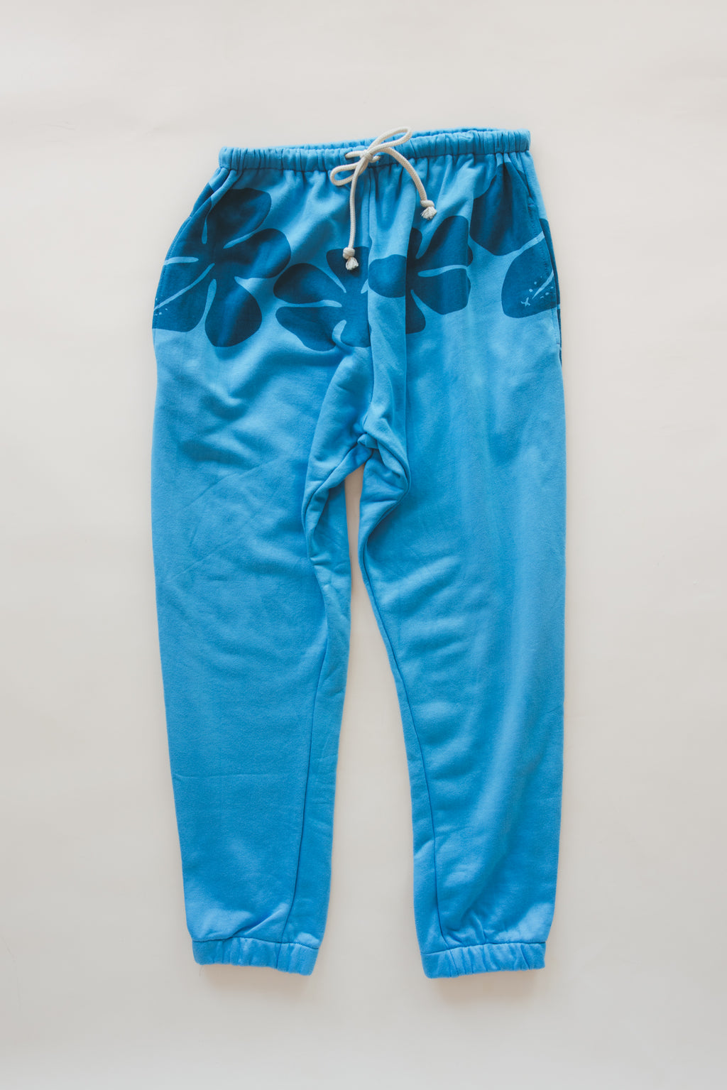 Wings Hawaii blue hibiscus joggers in bamboo french terry. Elevated loungewear  pants. Original artwork designed in Maui, hand sewn in Bali in small batches. Drawstring waist, mid-rise, pockets. 
