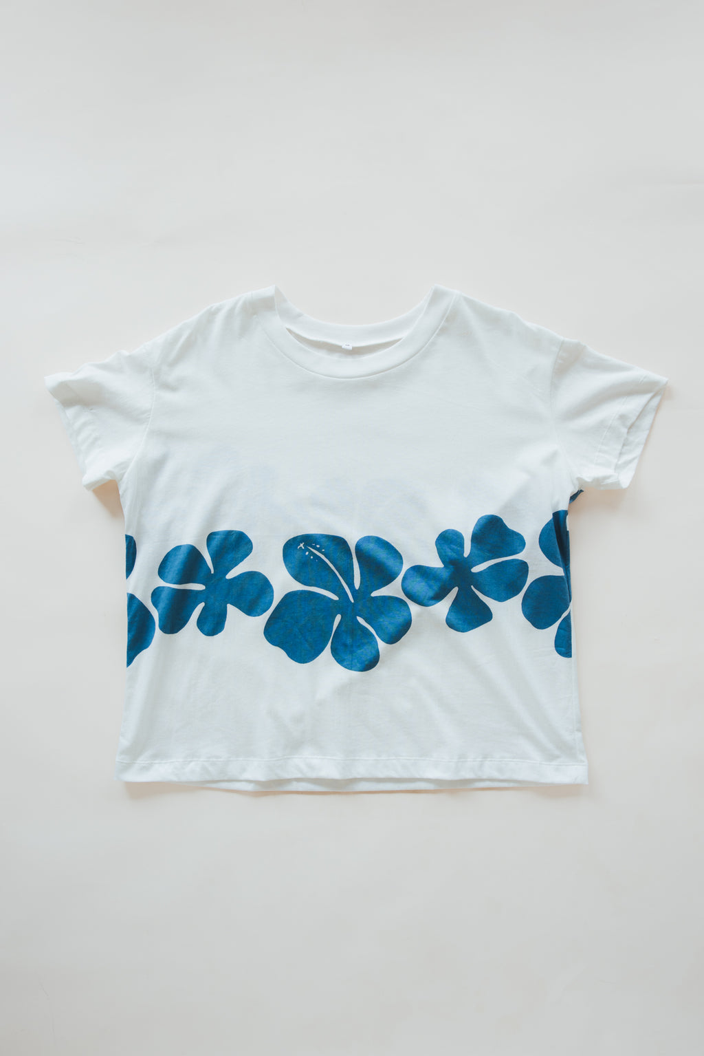 Wings Hawaii women's Hibiscus Tee in hemp. White with blue tropical floral print. Designed in Maui, made in Bali. Small batch, sustainable apparel. Vintage tropical aloha style vibes. 