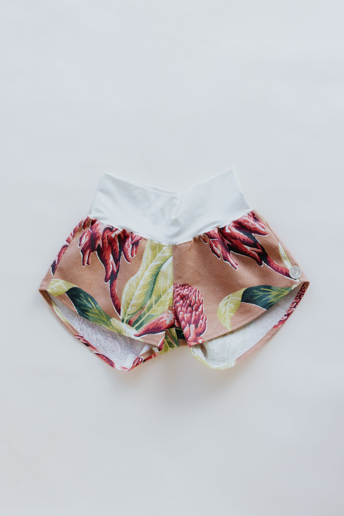 Wings Hawaii  Pau Hana Shorts in Torch Ginger. Handmade, one of a kind, upcycled vintage aloha fabric. Stretchy cotton waistband and back pocket. Made with aloha in Maui. Sustainable, small batch, high quality, slow fashion. 