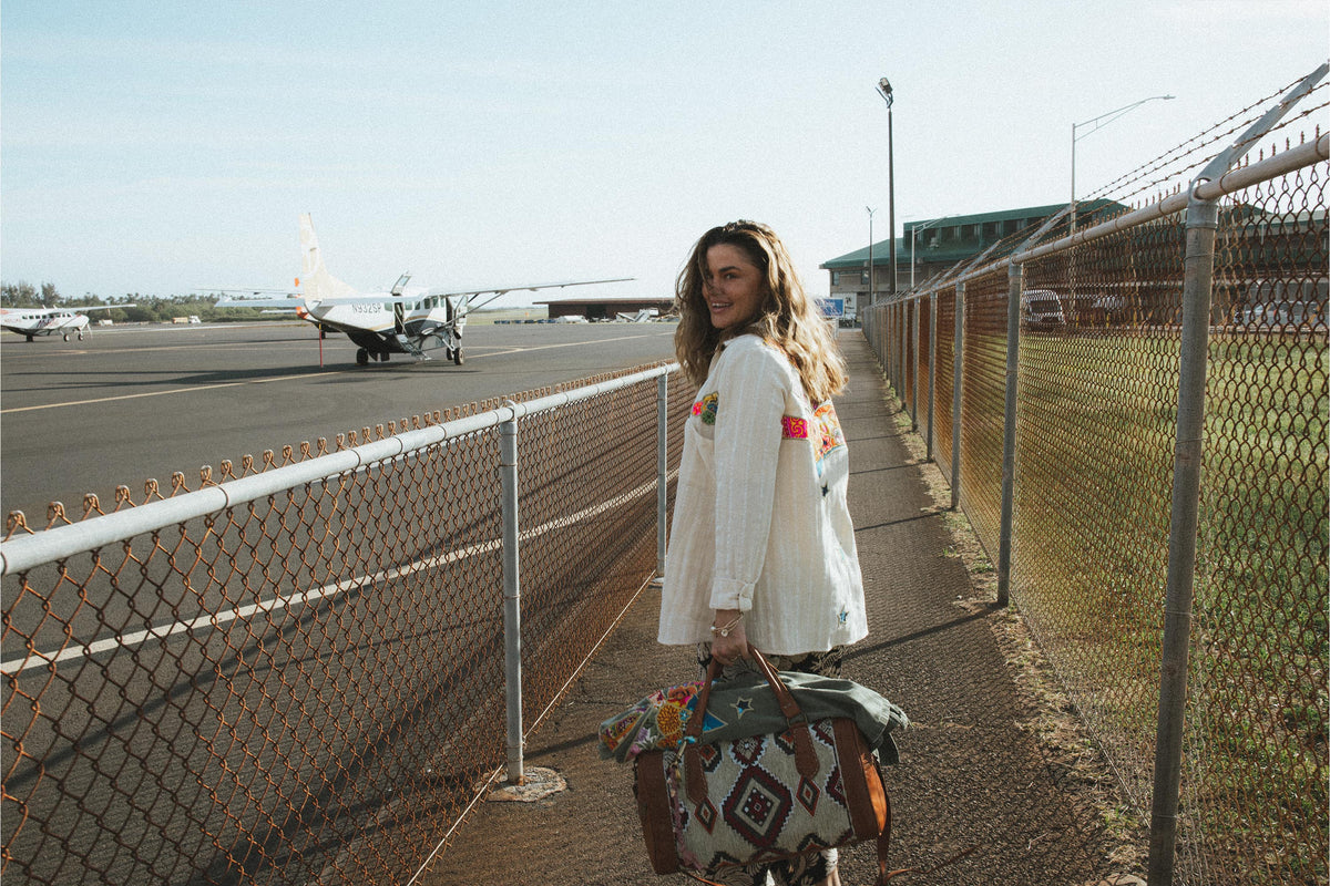 Model walking to a small plane on a runway
