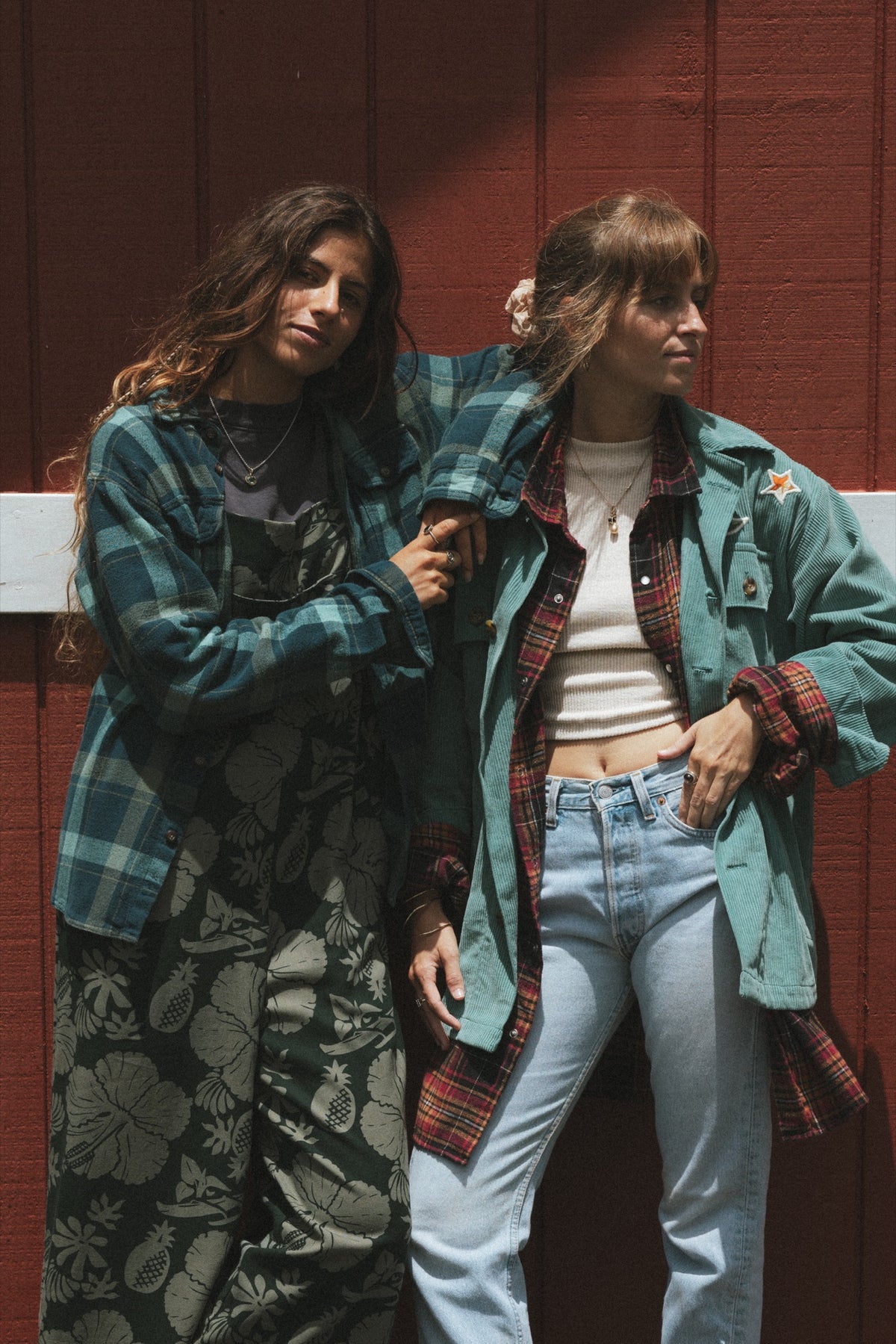 Two models in flannels against a red barn