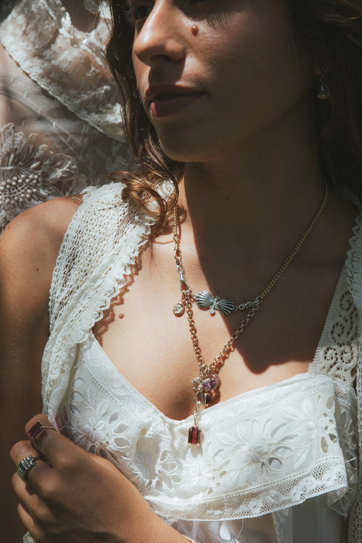 Layered Wings necklaces over a white lace dress
