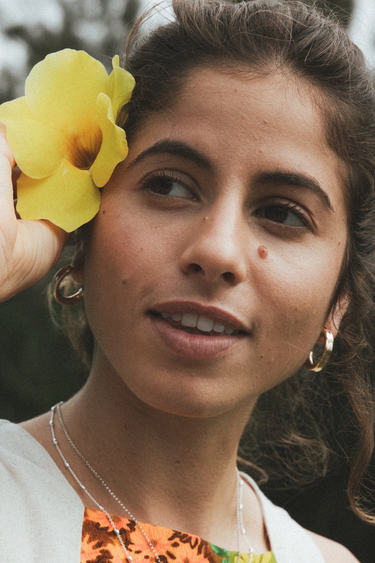 Model with a yellow flower in her hair wearing Wings earrings