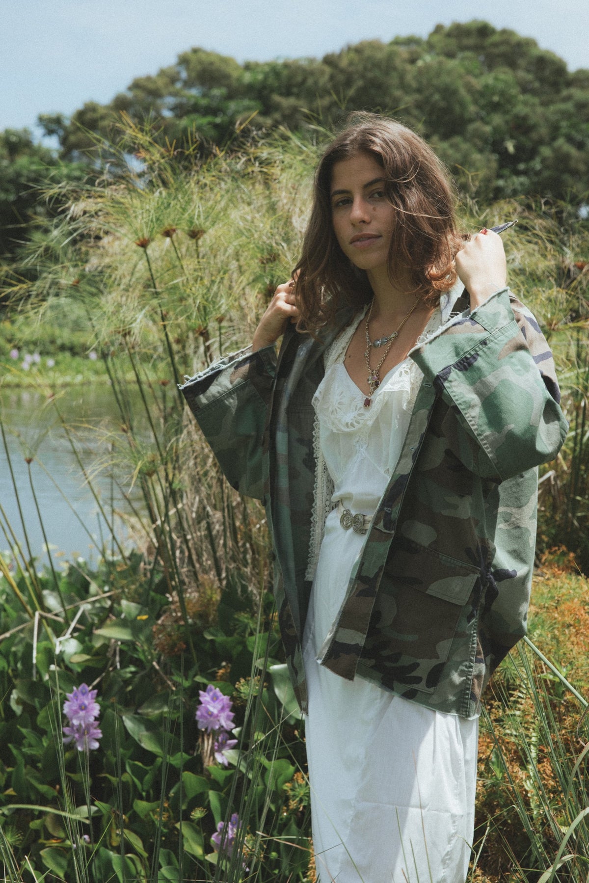 Model in a camo jacket in a field