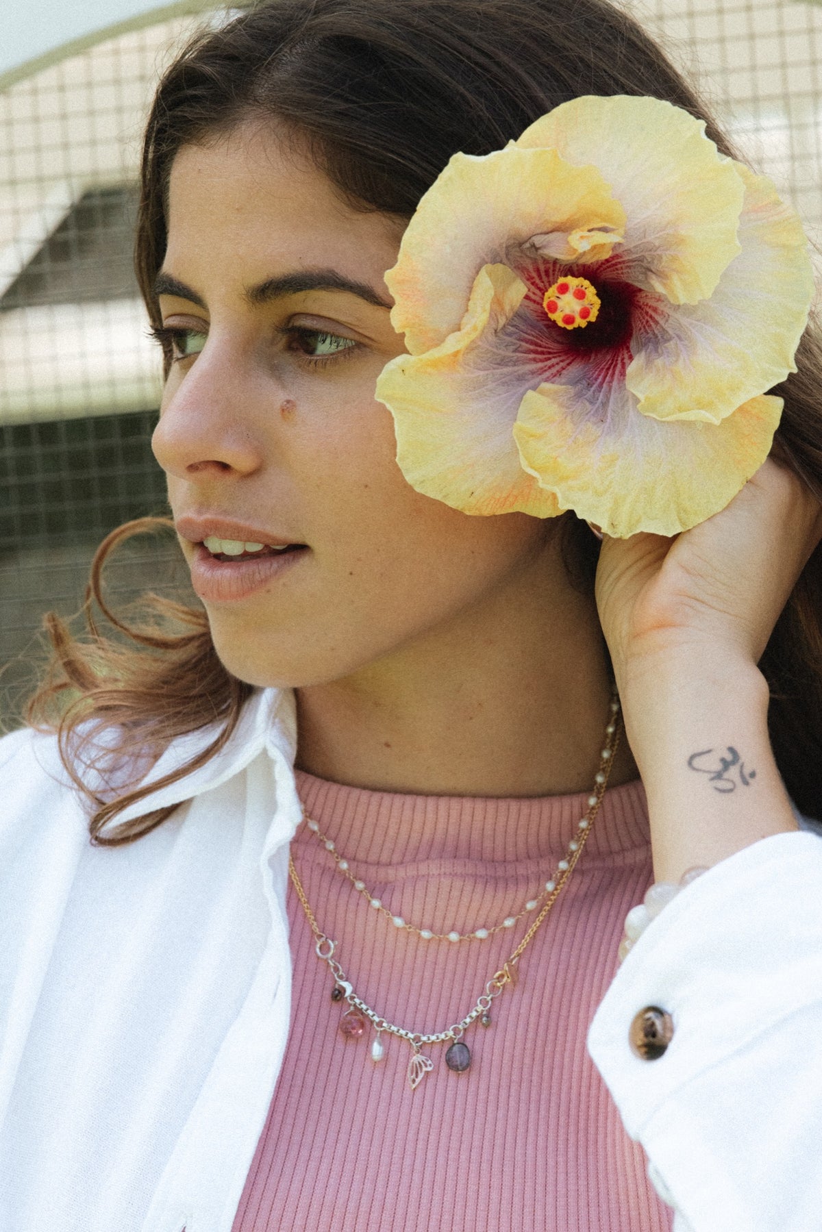 Model with a yellow hibiscus in the greenhouse