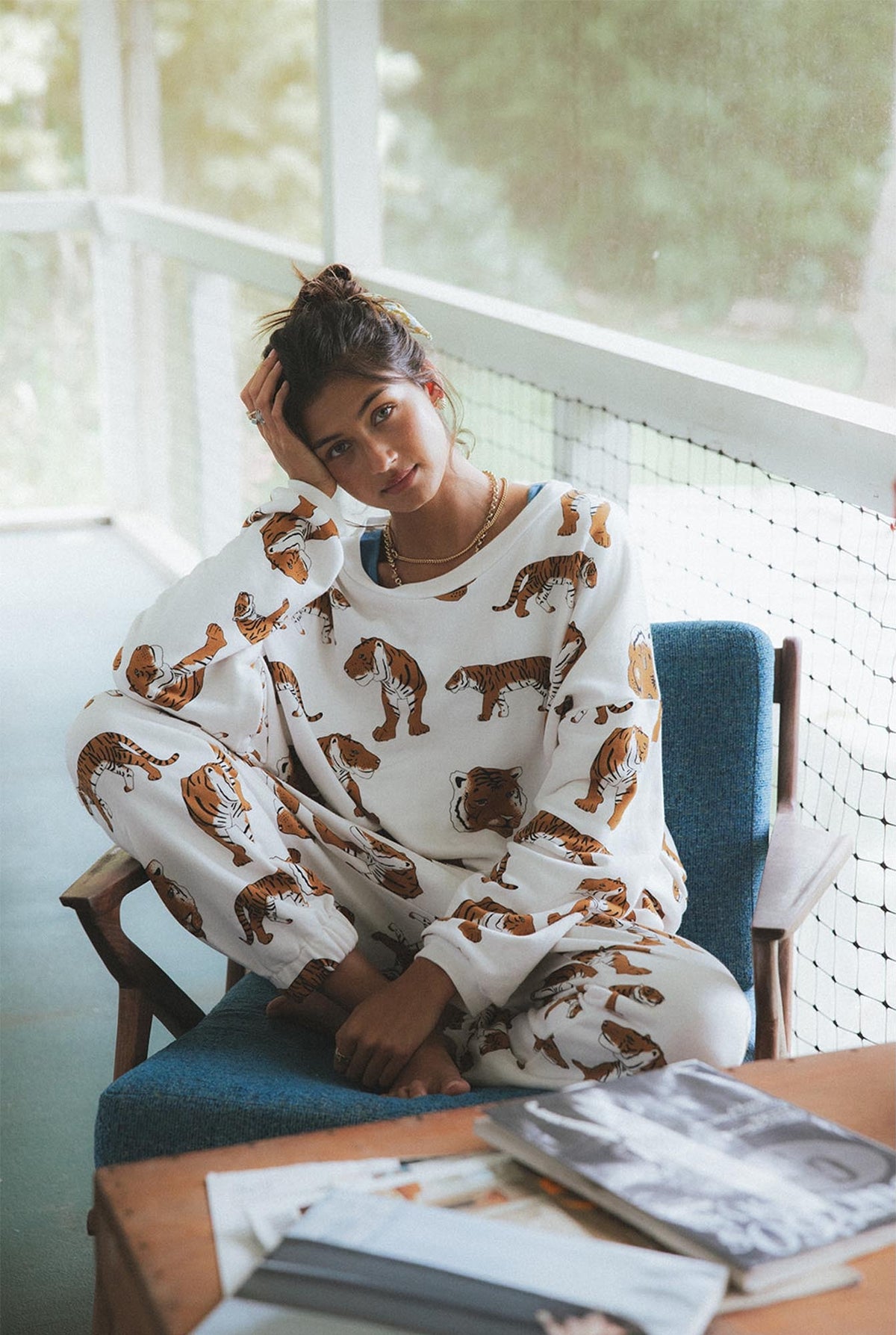 Model in a tiger print set sitting in a blue chair
