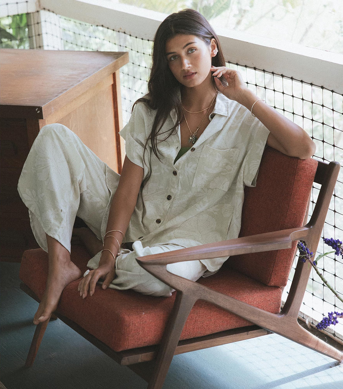 Model in a white aloha print set on a wooden chair