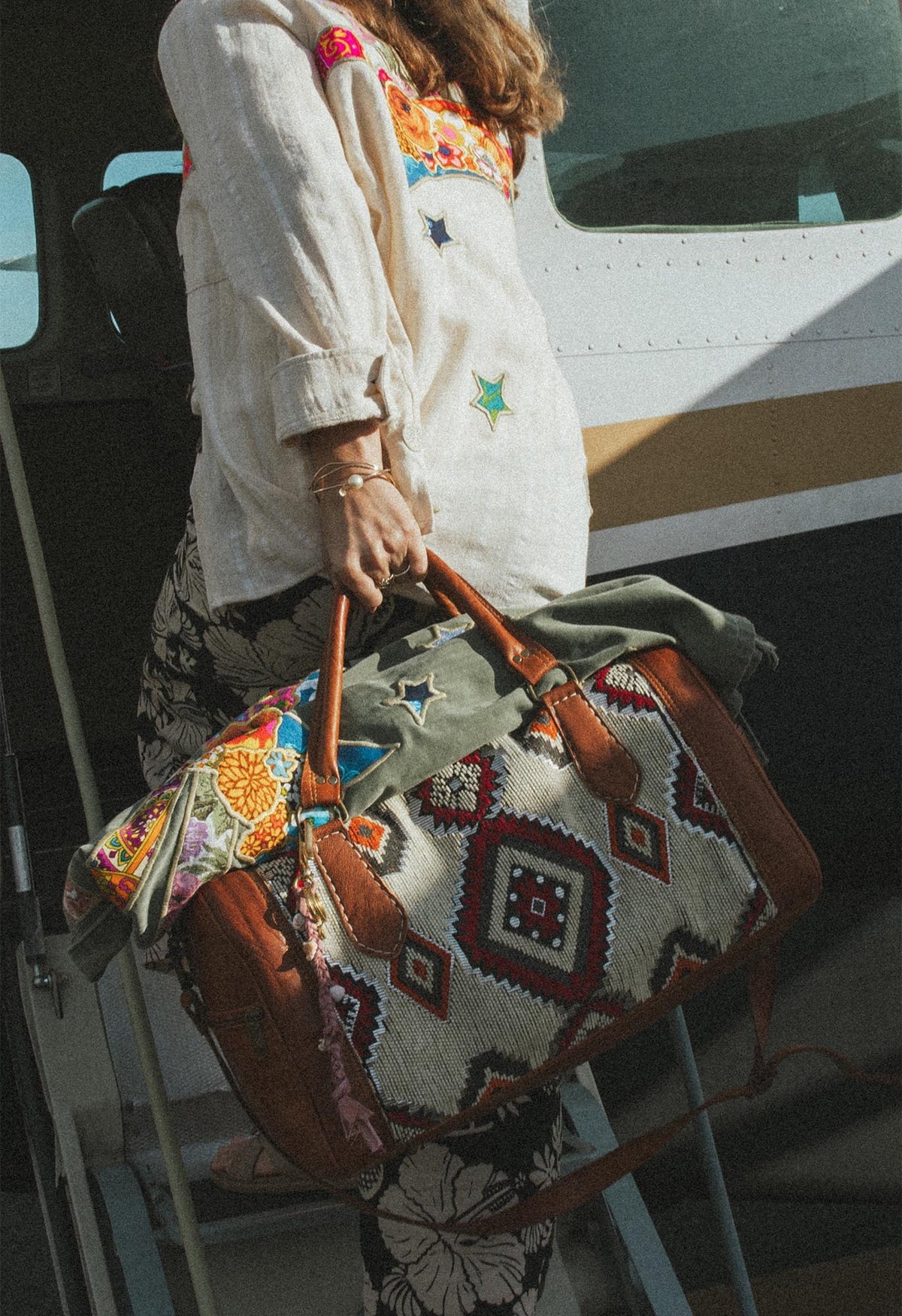 Model carrying a kilim travel bag