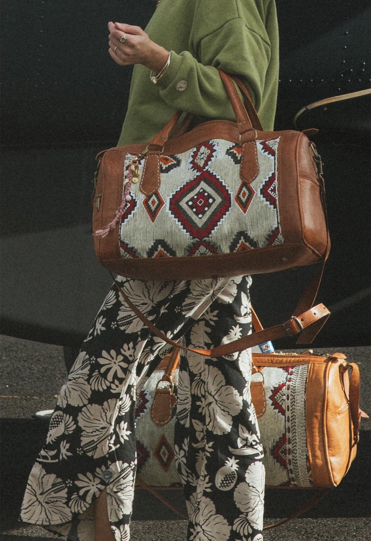 Model holding a kilim bag beside the plane