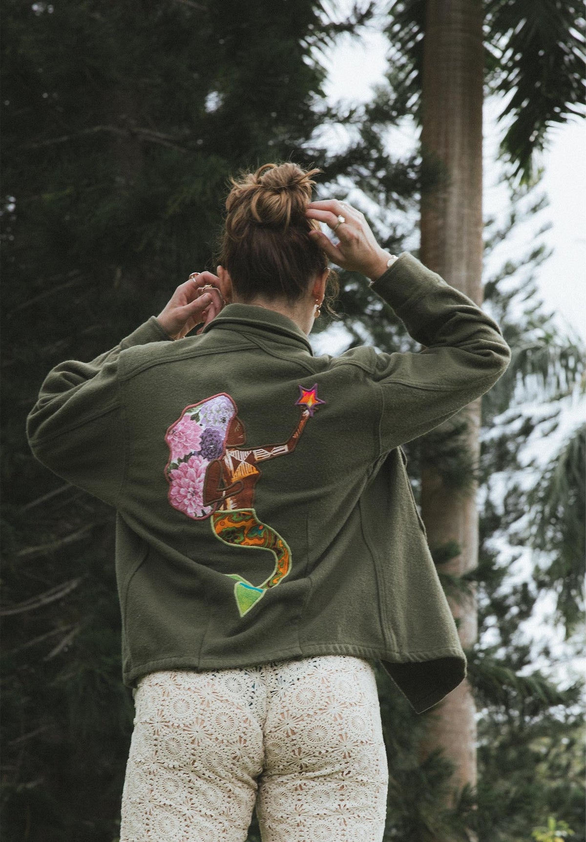 Back of an olive jacket with a mermaid embroidery