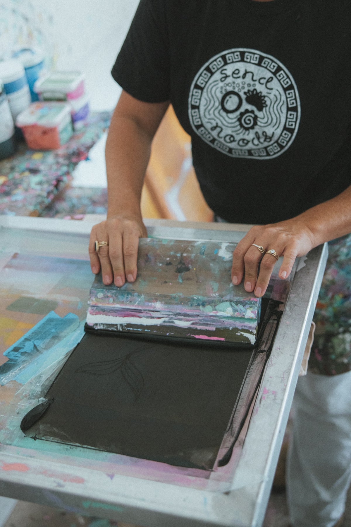 Pulling ink across a screen at the print table