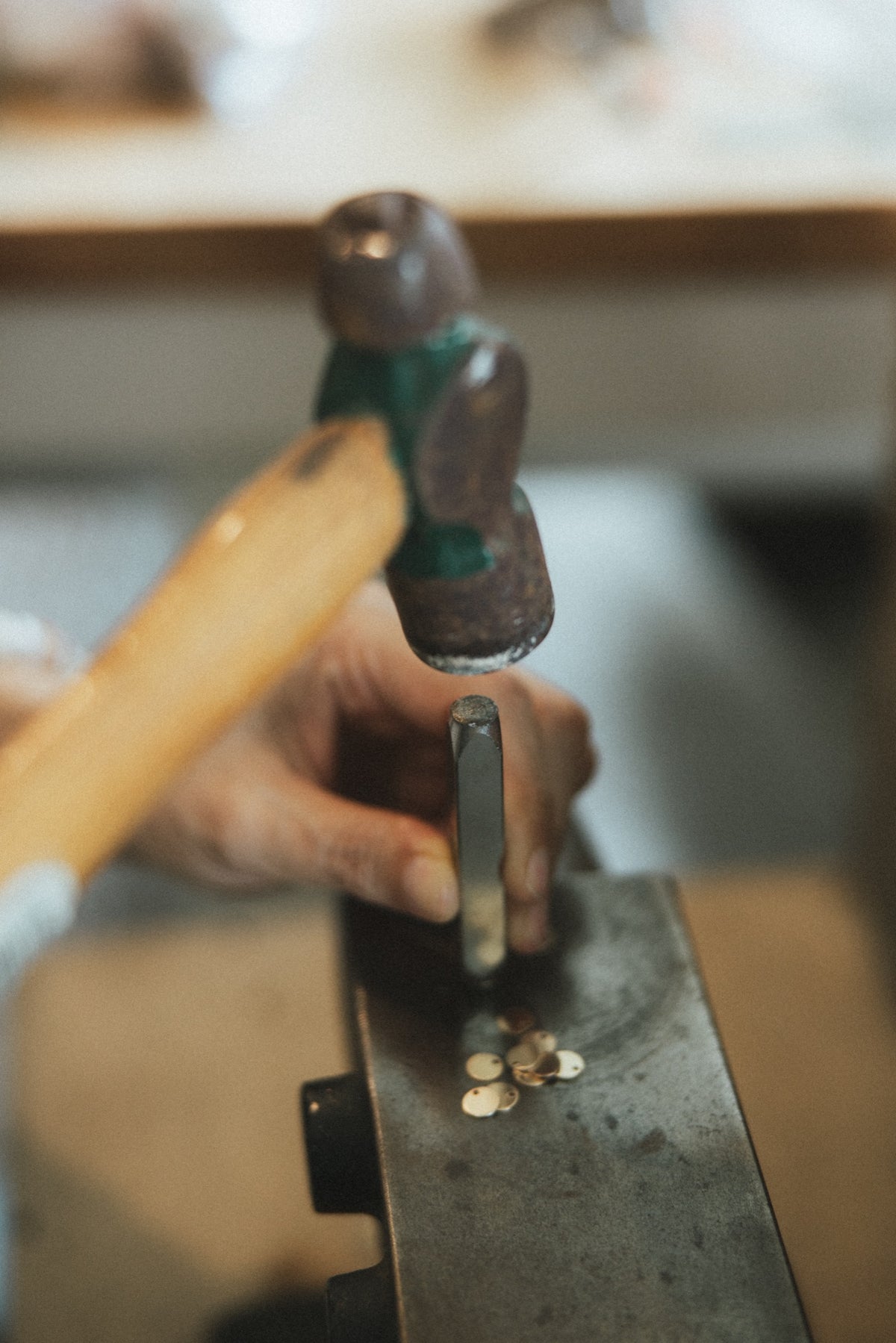 Hammer and steel stamp marking small metal pieces at the bench