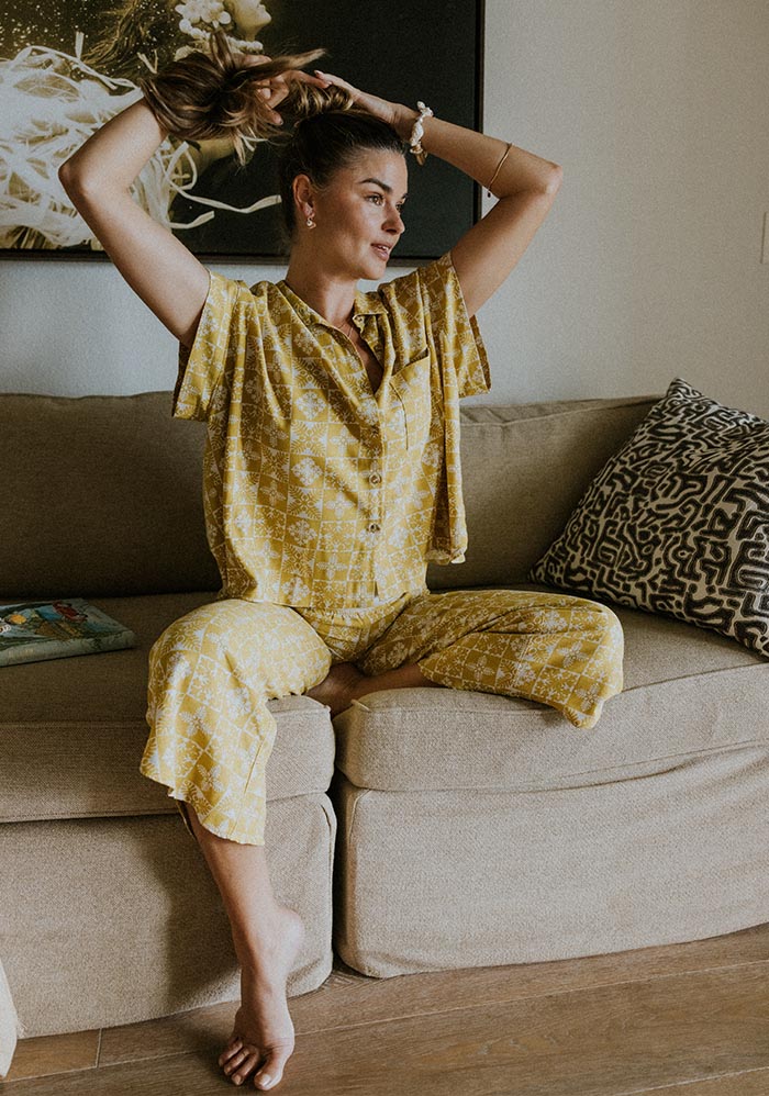Model in a yellow set sitting on a sofa