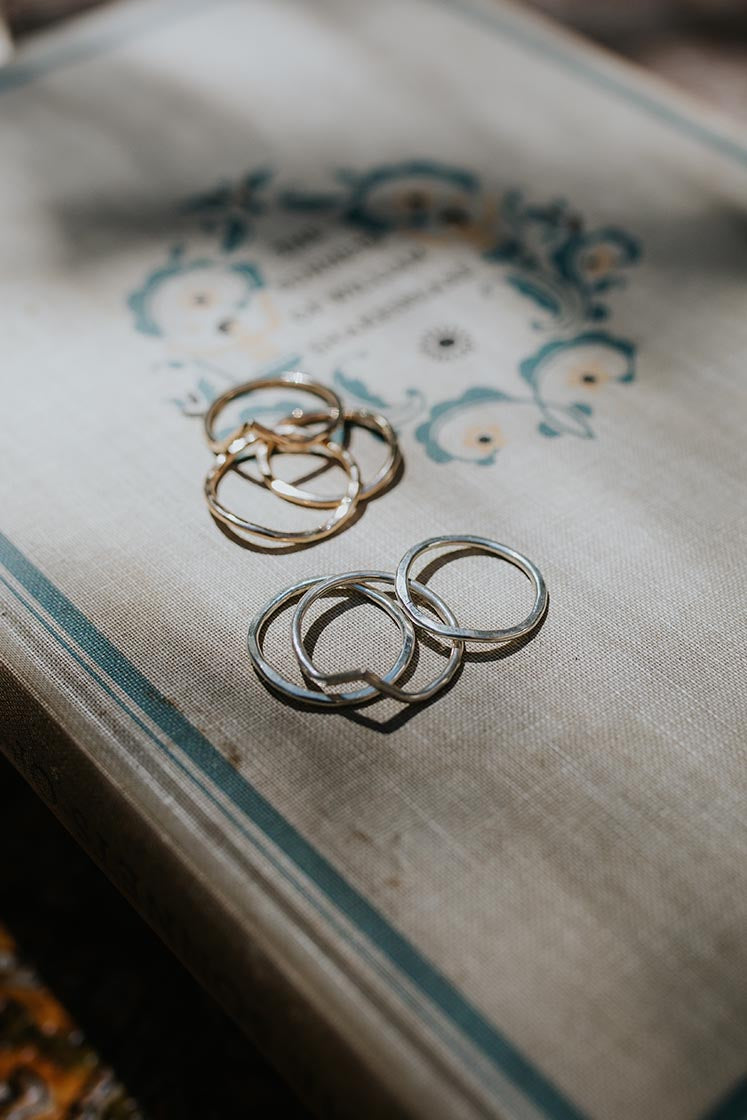 sterling silver and gold filled rings with a v shape sitting on a book